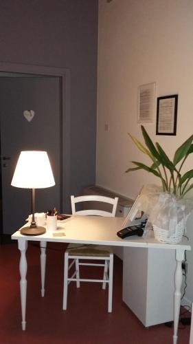 科拉迪拉齐塞Corte Mantovani的一张带灯和植物的白色书桌