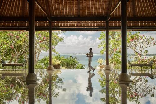 金巴兰金巴兰海湾巴厘四季酒店的站在别墅游泳池中间的人