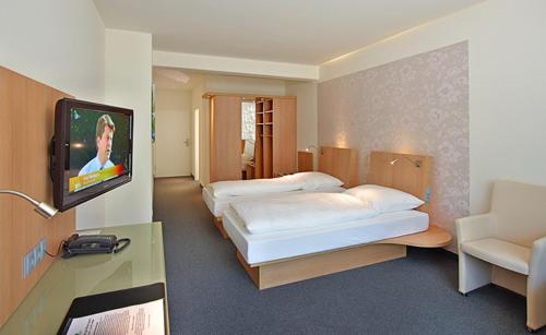 费尔登Thöles*** Am Allerpark Verden的酒店客房设有两张床和一台平面电视。