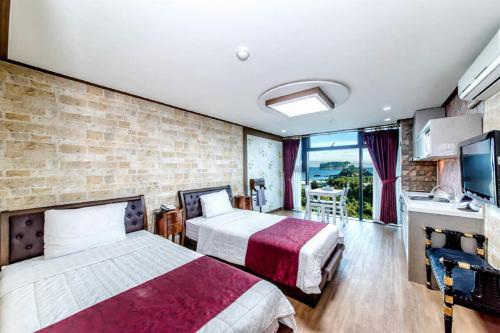 西归浦市奥利欧度假酒店的酒店客房设有两张床和一个阳台。