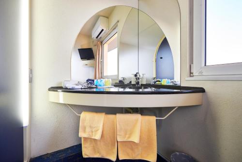 伊势崎市伊势崎精选酒店的浴室配有带镜子的盥洗盆和毛巾
