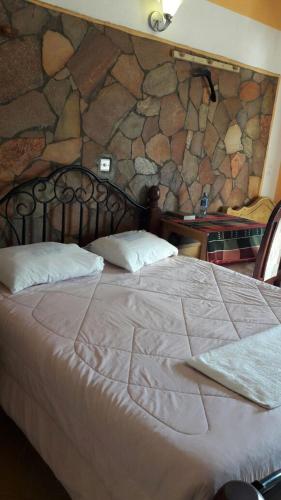 纳库鲁Marlin Guest Resort的石墙房间内的一张床位