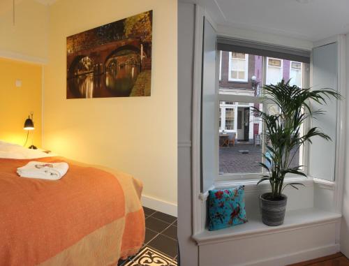 乌得勒支De Verrassing的卧室配有床,窗户旁种植了植物