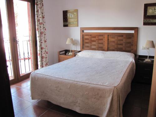 圣何塞Hotel-Apartamento Carolina y Vanessa的一间卧室设有一张大床和两个窗户。