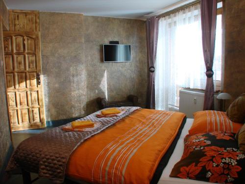 Vysoke Tatry - Horny SmokovecApartments Vysoké Tatry的卧室配有一张床,墙上配有电视。