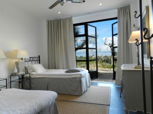 VillalfonsinaVillalfonsina Country House的一间卧室设有两张床和大窗户
