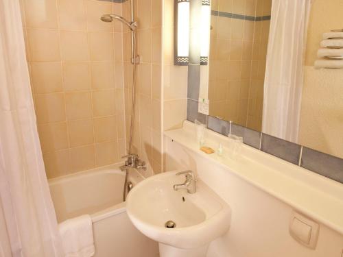 阿朗松钟楼阿伦松酒店的浴室配有盥洗盆、卫生间和浴缸。