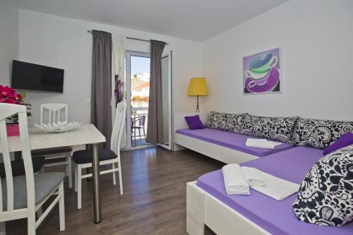 赫瓦尔Guest House Kovacevic的客厅配有紫色沙发和桌子