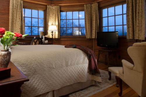 布卢明顿阵雨住宿加早餐旅馆的一间卧室设有一张床、一台电视和窗户。