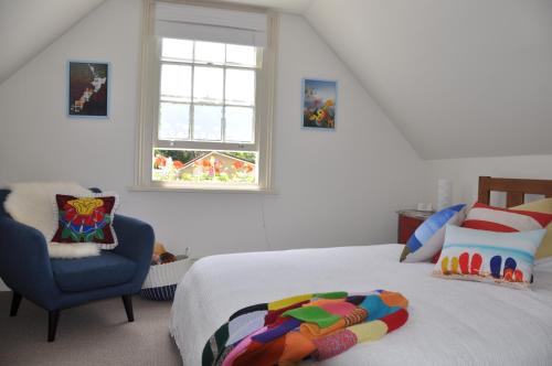 新普利茅斯Issey Manor的卧室配有床、椅子和窗户。