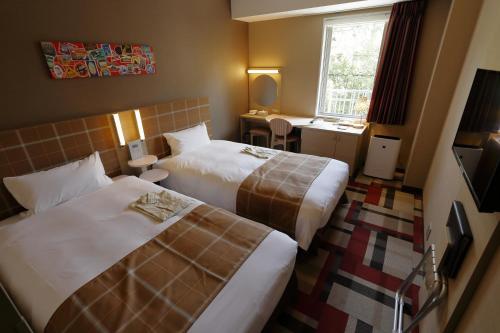 神户神户蒙特埃马纳酒店・艾美丽的酒店客房设有两张床和窗户。