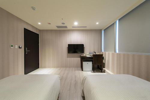 中坜新舍商旅中坜馆的一间卧室配有两张床、一张桌子和一台电视。