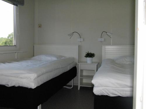 LjungsbroVreta Kloster Golfklubb的一间卧室设有两张床、一个窗口和两盏灯。