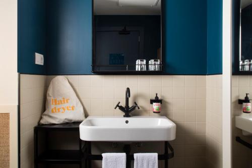巴塞罗那卡萨博馁酒店的浴室设有白色水槽和镜子