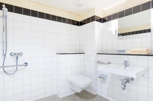 德累斯顿Hotel Am Weberplatz的白色的浴室设有卫生间和水槽。