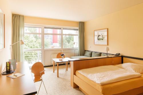 德累斯顿Hotel Am Weberplatz的一间卧室配有一张床、一张书桌和一个窗户。