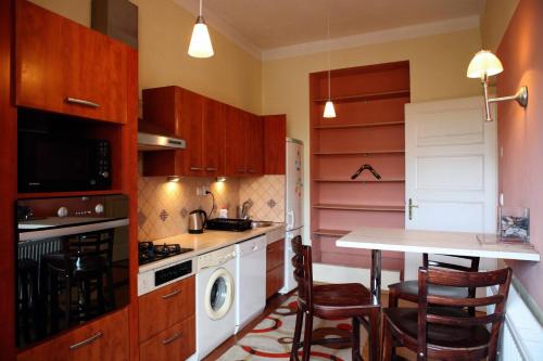 科希策Apartmán Moyzesova的厨房配有木制橱柜和桌椅