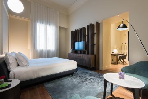 塞维利亚塞维利亚默瑟酒店的一间酒店客房,配有一张床和一台电视