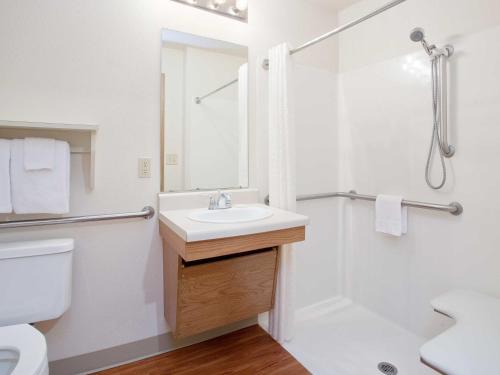 MerriamWoodSpring Suites Kansas City Mission的一间带水槽和淋浴的浴室