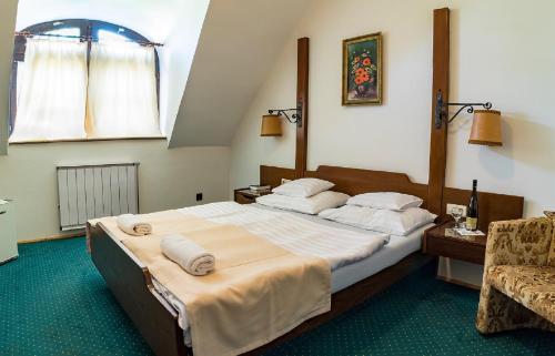 豪伊杜索博斯洛Gasthof Laci Betyár的一间卧室配有一张大床和一把椅子