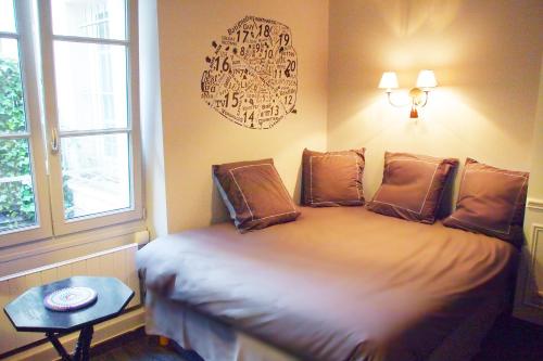 巴黎Petit Paris - Oasis in Marais的一间卧室配有一张带桌子和窗户的床