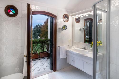 米拉玛格丽塔罗曼蒂克别墅酒店的一间带水槽和镜子的浴室
