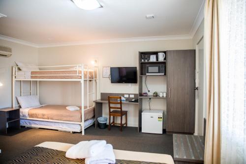 古尔本丁香城汽车旅馆及牛排餐厅的客房设有两张双层床和一张书桌。