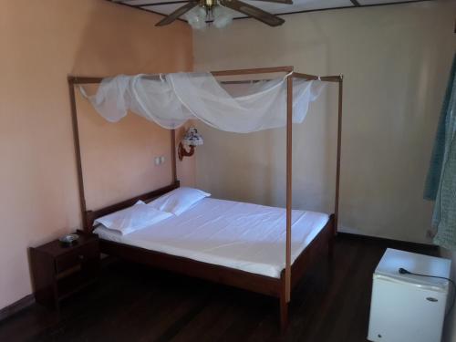 迭戈苏瓦雷斯Hotel Valiha的一间卧室设有天蓬床和卫生间