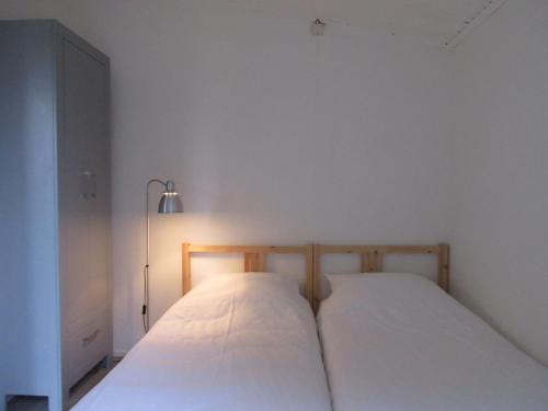 巴勒姆Zeealsem的配有2张床的白色墙壁和一盏灯