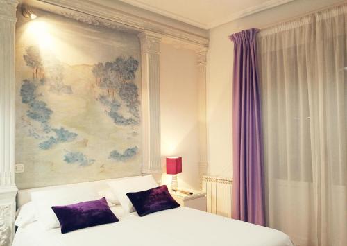 马德里特拉安旅馆的一间卧室配有一张壁画床