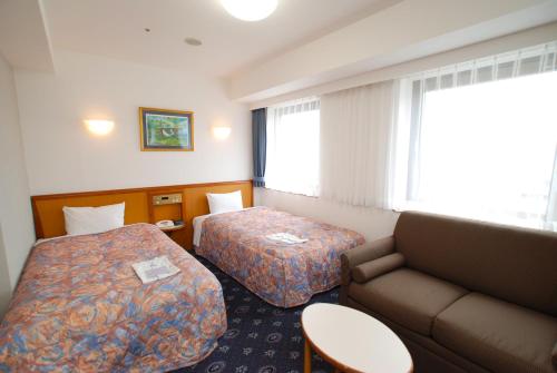 舞鹤市阿斯丁酒店的酒店客房,设有两张床和一张沙发
