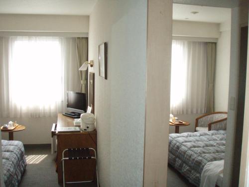 四万十市四万十新皇家酒店的酒店客房配有两张床和一张书桌