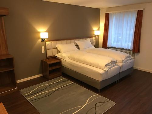 卢塞恩罗特塞福肯艾姆酒店的一间卧室设有一张大床和一个窗户。
