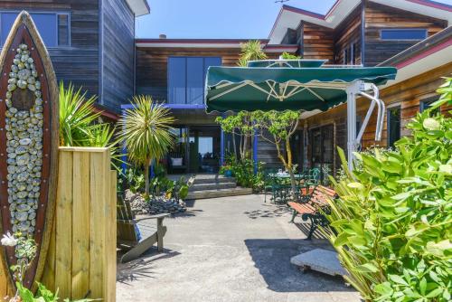 纳皮尔绝对海滨住宿加早餐旅馆的庭院设有椅子和遮阳伞,种有植物