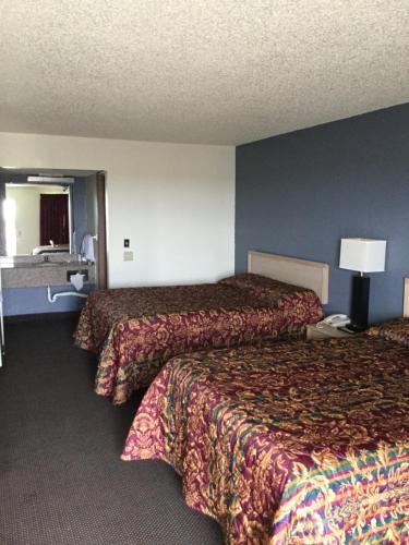 WaukomisCountry Inn Motel的酒店客房,设有两张床和一盏灯
