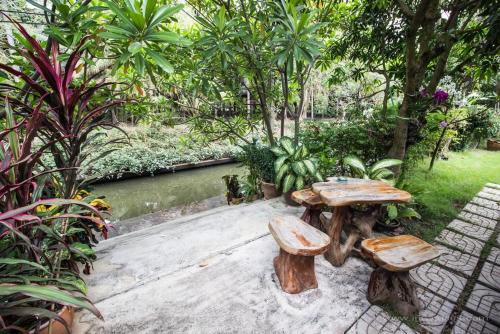 Damnoen Saduak班兰可龙度假村的花园内的木桌和长椅