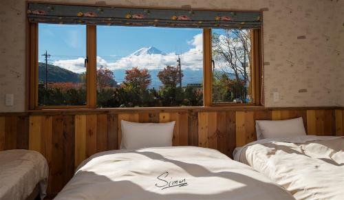 富士河口湖河口湖南别墅的带大窗户的客房内的两张床