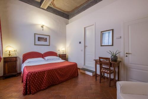 佛罗伦萨B&B Home in Florence的一间卧室配有红色的床和一张桌子及椅子