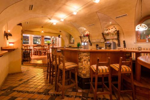 富尔普梅斯Adler Hotel-Pension的餐厅的酒吧,带木凳