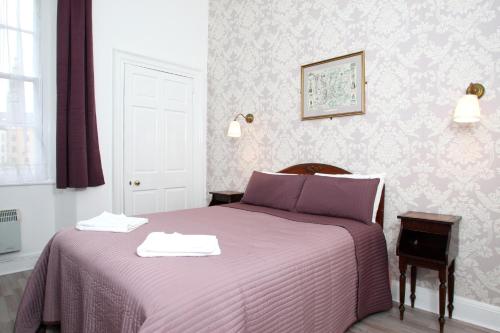格拉斯哥52 Charlotte Street , Glasgow green ,City Center的一间卧室配有一张紫色床和两条毛巾