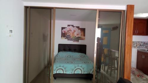 菲兰迪亚Apartahotel Calle del tiempo detenido的卧室配有小床,位于玻璃箱内
