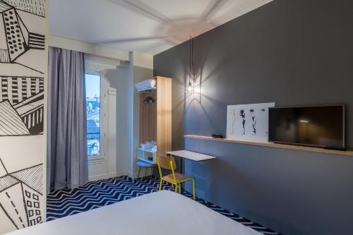 巴黎巴黎意大利广场鹌鹑之丘宜必思尚品酒店 的酒店客房设有一张床、一张书桌和一台电视机。