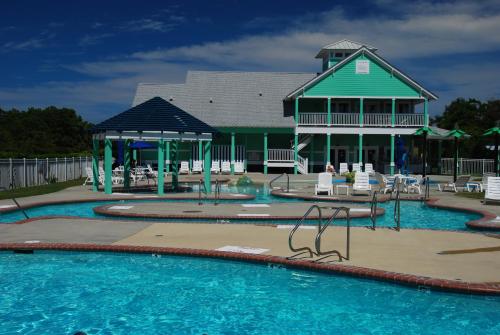 斩魔山汉密尔顿岛百慕大湾基斯度假村的一个带游乐场和房子的游泳池