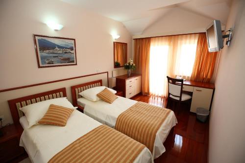 特罗吉尔特洛吉尔宫殿酒店的酒店客房配有两张床和一张书桌