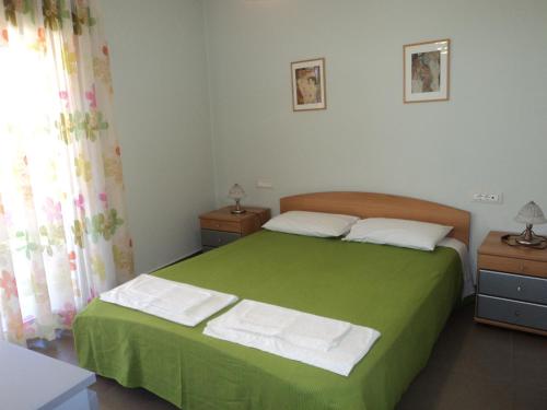 雷夫卡达镇Violeta Apartments的一间卧室配有带2个床头柜的绿色床
