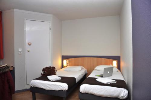 尼奥尔普瑞米尔尼奥特伊斯特夏雷经典酒店的酒店客房设有两张床,上面有笔记本电脑