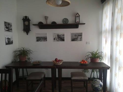戈里察Hotel Bujtina e Bardhe的植物和钟表的房间的桌子