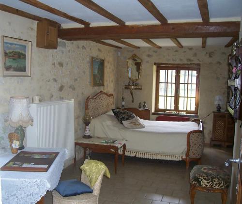 贝莱姆Maison d'Hôtes Les Après的一间卧室配有一张床、一张桌子和一张沙发