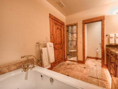 大天山村Cowboy Heaven Suites-Unit 2B的大型浴室设有浴缸和淋浴。