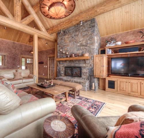大天山村Lone View Lodge的客厅设有石制壁炉和电视。